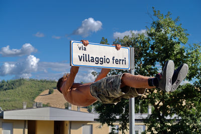 Low angle view of road sign against sky