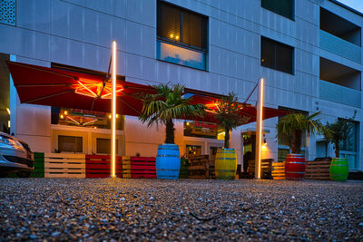 Illuminated road by building at night