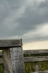 Close-up of wooden post by sea against sky
