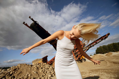 Midsection of woman holding umbrella against sky