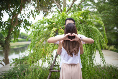 Rear view of woman standing by plants