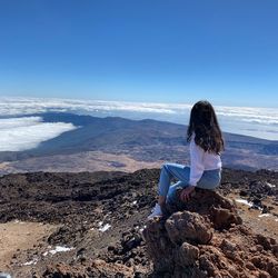 Woman sitting on rock looking 