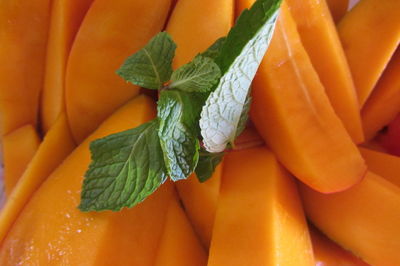 Close-up of fresh mango slices with mint leaves