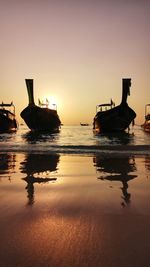 Silhouette ship in sea against sky during sunset