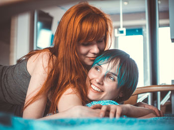 Smiling lesbian couple lying on bed at home