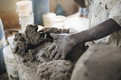 Midsection of potter working with clay at pottery