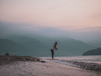 Full length of man standing on land against sky during sunset