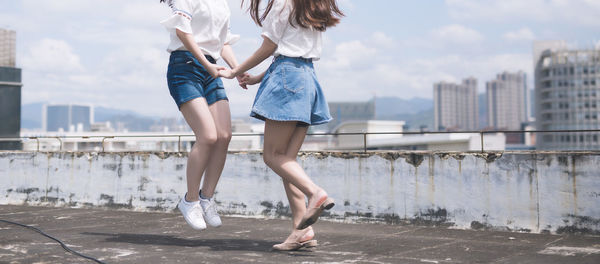 Low section of women dancing on rooftop