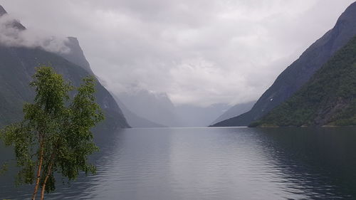 Idyllic shot of lake amidst mountains against cloudy sky