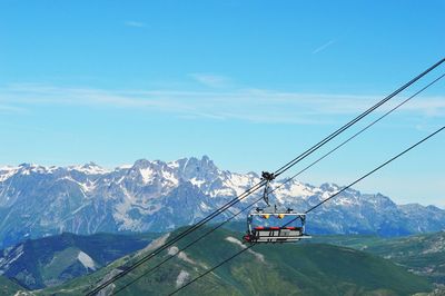 Low angle view of overhead cable car against blue sky