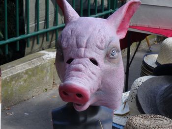 High angle view of pig mask by hat at market stall