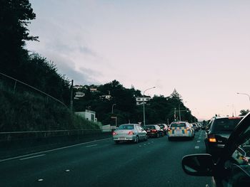 Traffic on road in city against sky