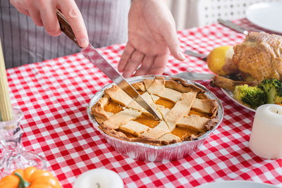 Cropped hand of person preparing food on table