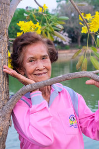 Portrait of smiling woman with pink leaves