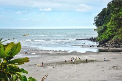 People on beach against sky