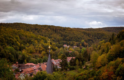 Trees and houses against sky during autumn