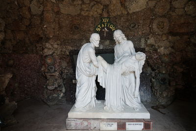 Statue of buddha against wall