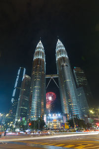 Low angle view of illuminated buildings against sky at night