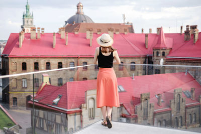 Full length of woman standing against buildings in city