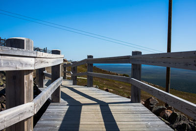 Bridge over sea against clear blue sky