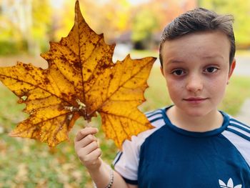 Portrait of boy on leaves during autumn