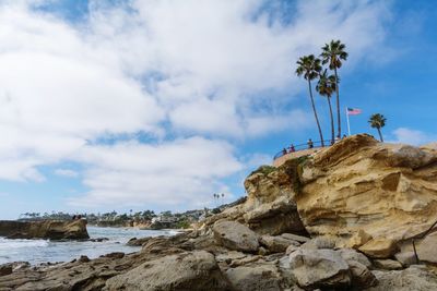 Rock formation on beach against sky