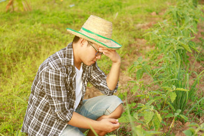 Man wearing hat sitting in farm