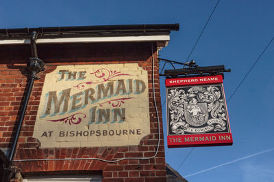 Low angle view of information sign against sky