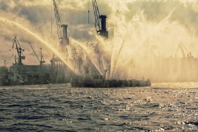 View of cranes next to sea