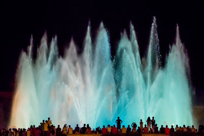 Panoramic view of crowd at concert against sky at night