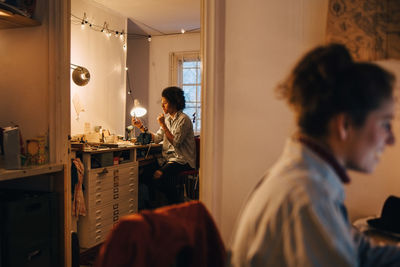 Technician working at desk with woman sitting in foreground