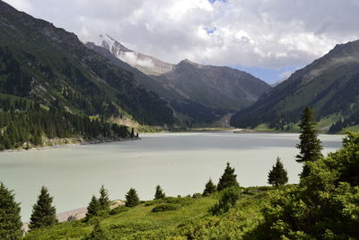 Scenic view of mountains and lake against cloudy sky