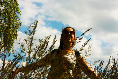 Low angle view of man wearing sunglasses against sky