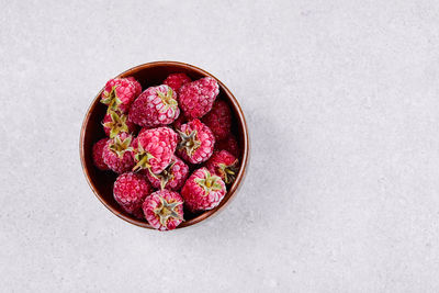 High angle view of pink fruits on table against white background