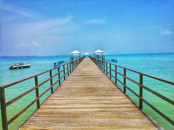 Pier over sea against blue sky