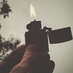 Close-up of person holding burning candle