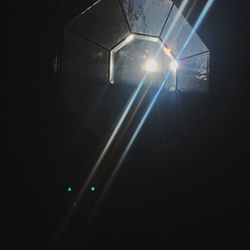 Low angle view of illuminated lights against sky at night