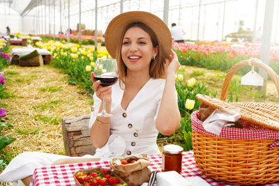 Attractive young woman having appetizer among tulip flowers