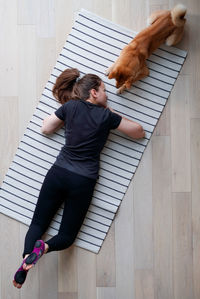 High angle view of woman lying on wooden floor