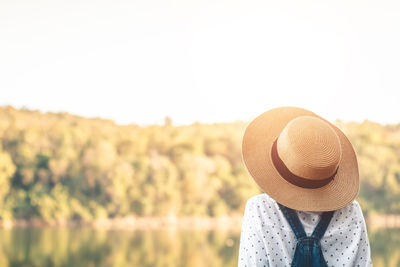 Rear view of woman wearing hat against clear sky