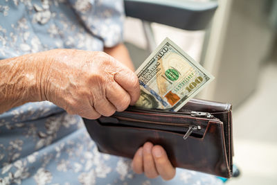 Midsection of man holding paper currency