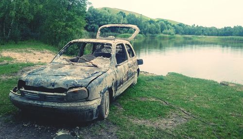 Abandoned vehicle on tree against sky