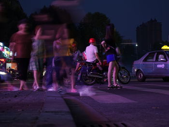 People riding motorcycle on road at night
