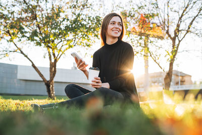 Portrait of young woman sitting on field