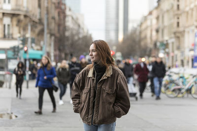 Woman standing on city street in winter