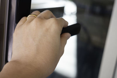 Close-up of hand holding glass window