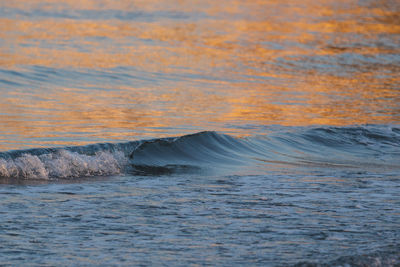 Scenic view of waves during sunset