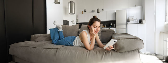 Portrait of woman sitting on bed at home