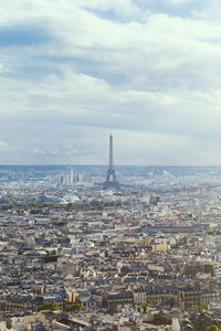 View of cityscape against cloudy sky