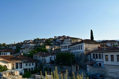 Buildings in town against clear blue sky